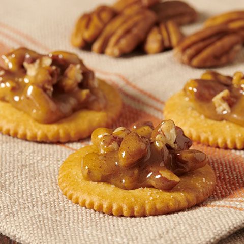 three cookies with pecans and caramel drizzled on top are sitting on a towel