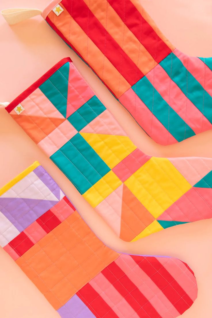 three pieces of colorful quilted material laying on top of each other in different colors