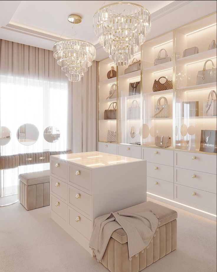 a large closet with white furniture and chandelier hanging from the ceiling