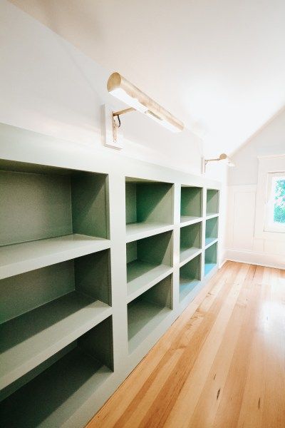 custom built-in bookshelves, bookshelf lights, attic bedroom nook, reading nook, window seat, custom built-ins Attic Renovation Playroom, Built In Shelves Knee Wall, Playroom Sloped Ceiling, Modernize Victorian Home, Office Attic Ideas, Attic Room Storage Ideas, Attic Library Sloped Ceiling, Attic Cabinets, Attic Shelving