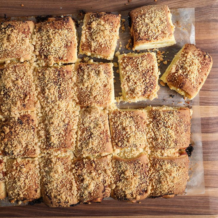 square pieces of bread with crumb toppings on a cutting board next to a knife