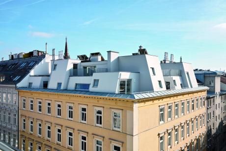 an apartment building with many windows and roofs