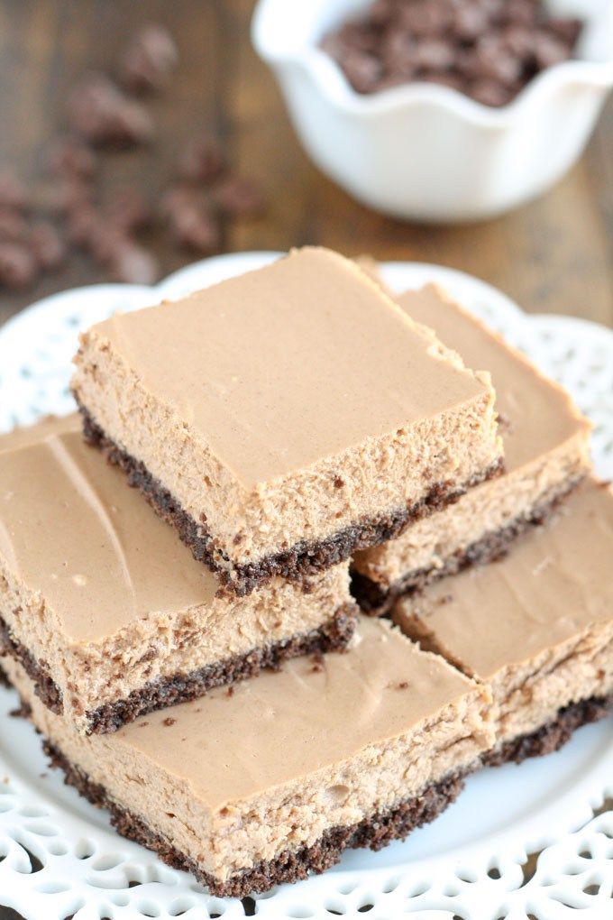 three pieces of cake sitting on top of a white plate next to a bowl of chocolate chips