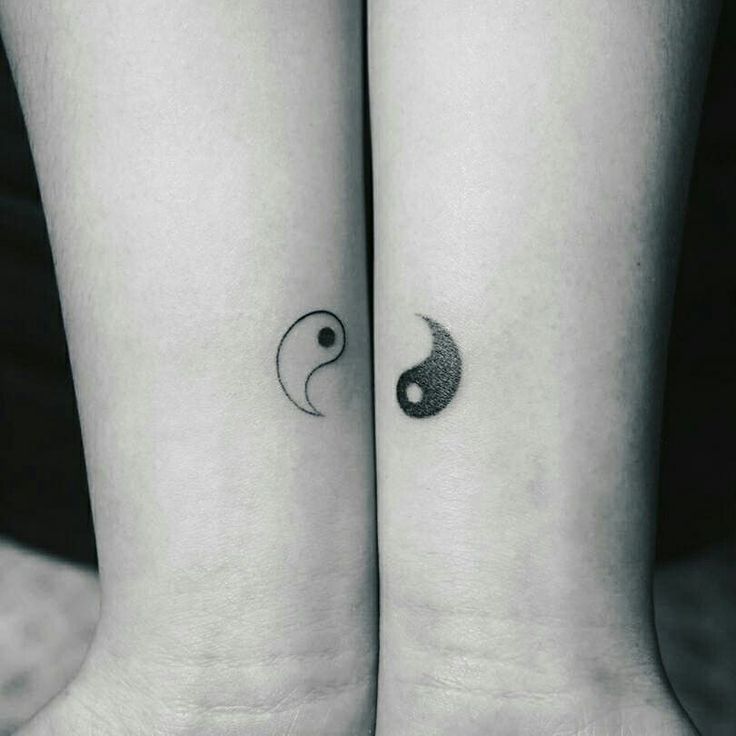 two small tattoos on the wrist that look like yin - and - yang are shown