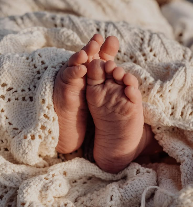 a baby's feet are laying on a blanket