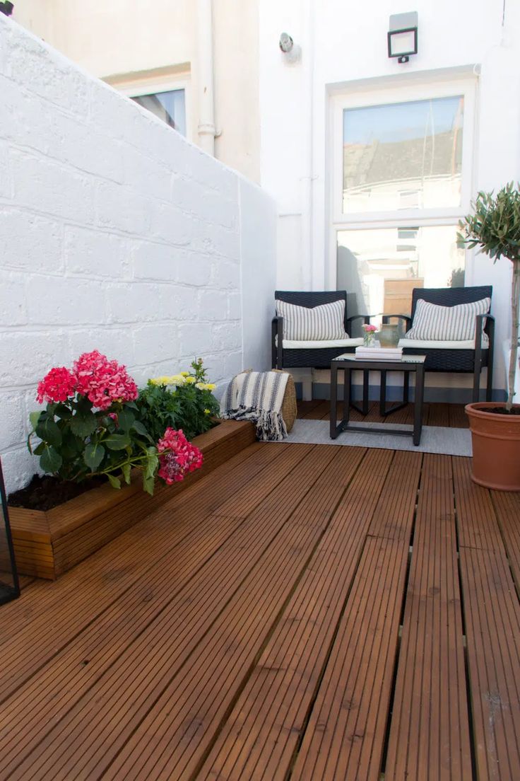 a wooden deck with potted flowers on it