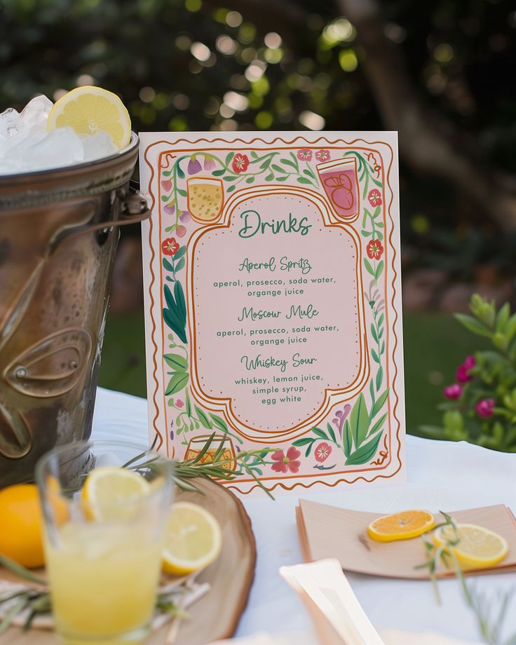 a table topped with drinks and menus next to a bucket filled with lemons