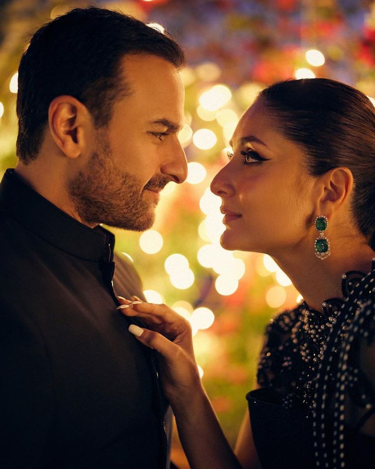 a man and woman standing next to each other in front of a lit christmas tree