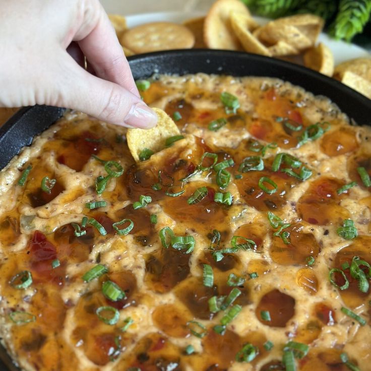 a person dipping some food into a skillet