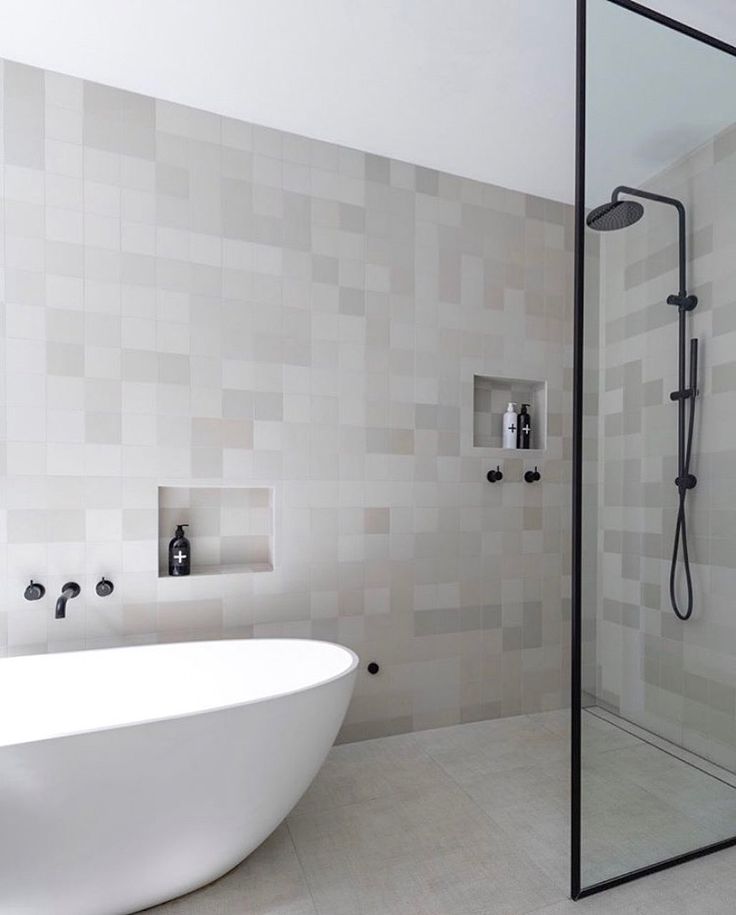 a white bath tub sitting next to a walk in shower under a faucet