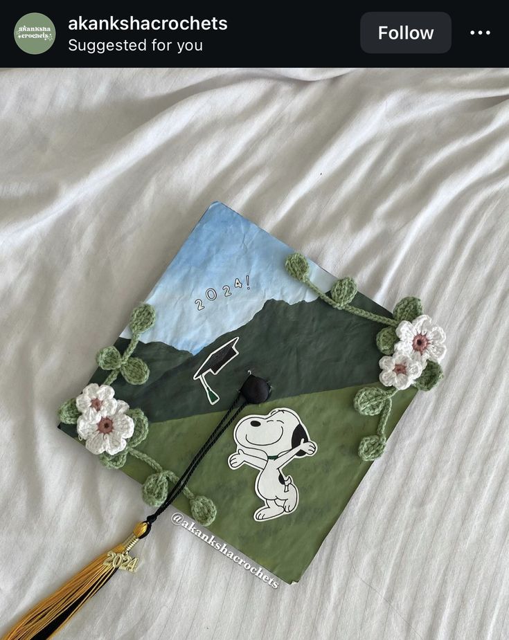 a book that is laying on top of a bed with a tassel in front of it