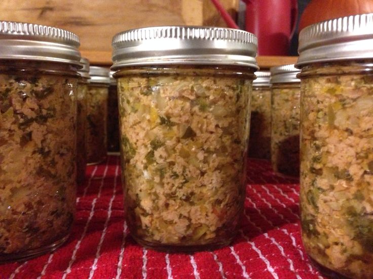 four jars filled with food sitting on top of a table