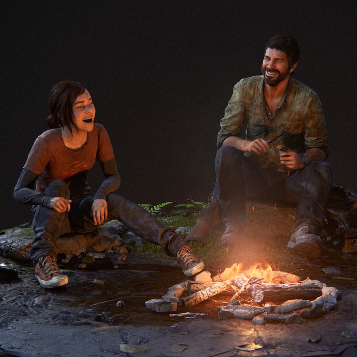 two people sitting around a campfire in the dark with one person holding a knife