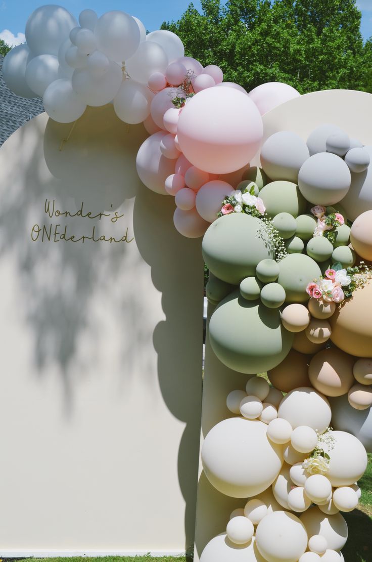 balloons and flowers are arranged on the side of a wall