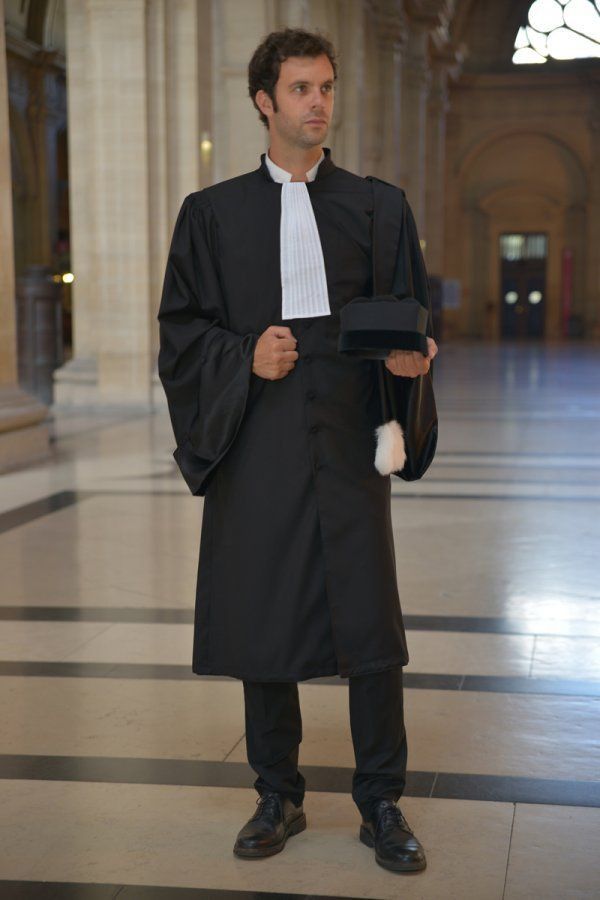 a man in a black robe and hat holding a book while standing on a marble floor