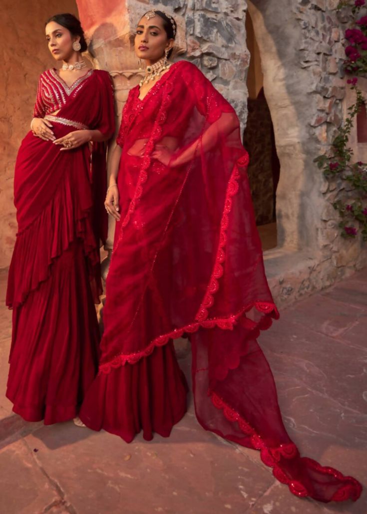 This gorgeous red drape sari in georgette with crinkle detailing is paired with fully embroidered sequins and beaded blouse. The blouse is padded, have side zip closure and have a flattering v-neck line. The outfit is paired with embroidered belt. Red Pre-draped Saree With Sheer Dupatta In Dola Silk, Red Traditional Blouse With Sheer Dupatta, Red Blouse With Sheer Dupatta For Festivals, Elegant Red Embellished Pre-draped Saree, Red Blouse With Sheer Dupatta For Party, Festive Red Blouse With Sheer Dupatta, Red Embellished Pre-draped Saree, Red Embellished Chanderi Traditional Wear, Red Embellished Georgette Sharara