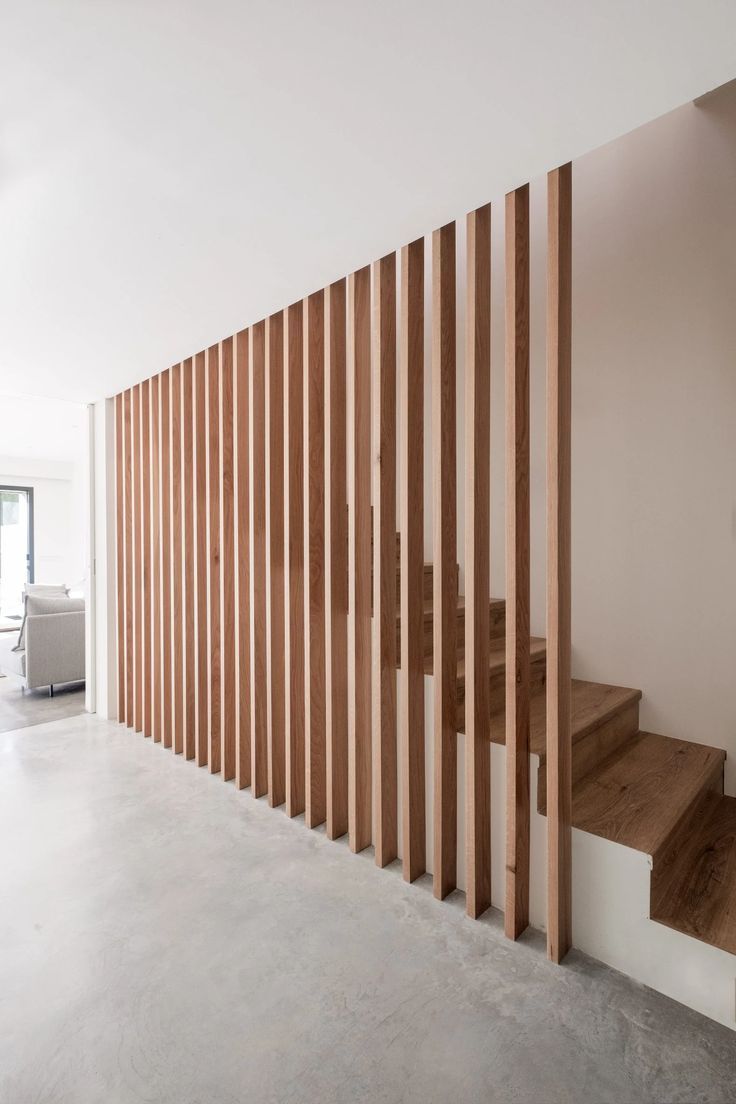 an empty room with wooden slats on the wall and stairs leading up to it