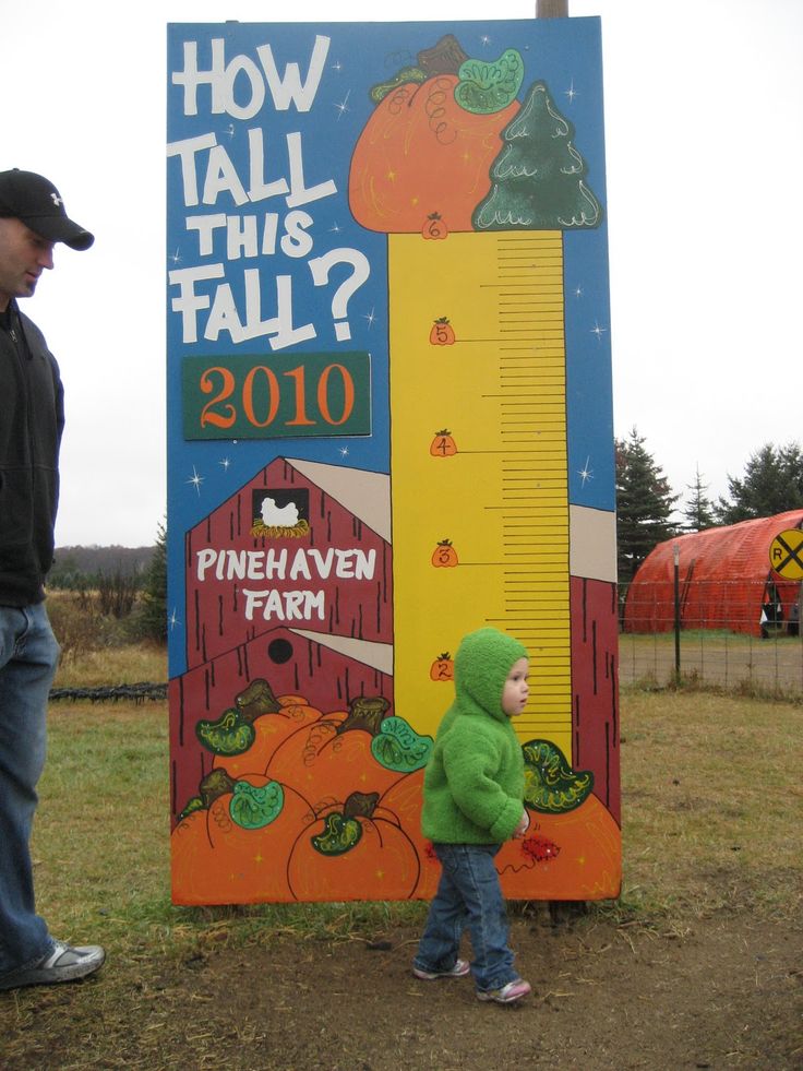 a young child standing next to a tall sign