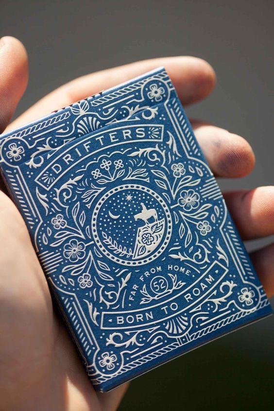 a person holding a blue playing card in their hand