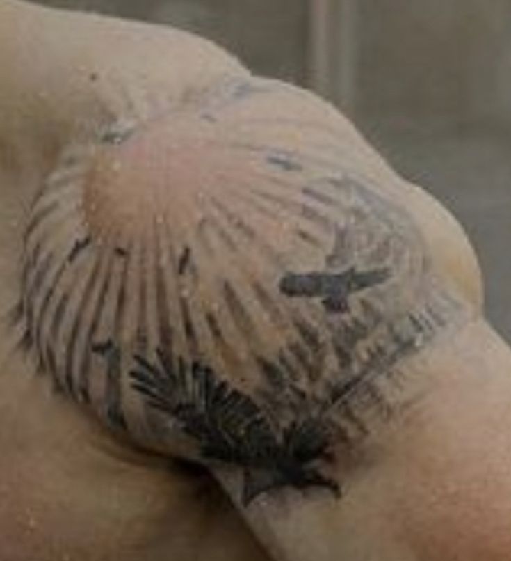 the back of a man's head with tattoos on it