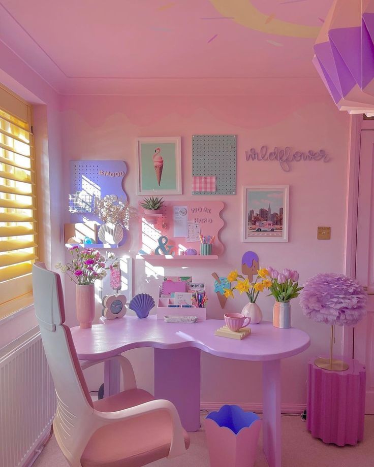 a pink desk and chair in a room with pictures on the wall above it, along with other decorations