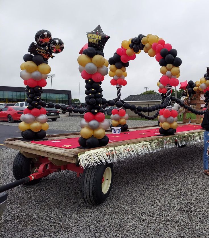 two people standing next to a trailer that has balloons on it and the word love spelled out