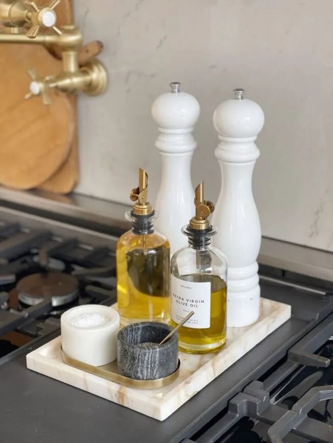 two bottles are sitting on top of a stove burner with candles and soap dispensers