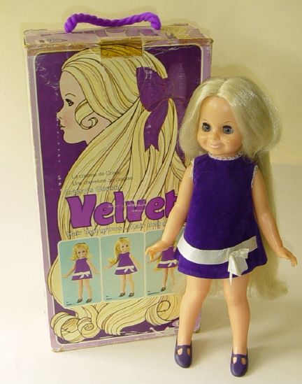 a doll with blonde hair standing next to a box