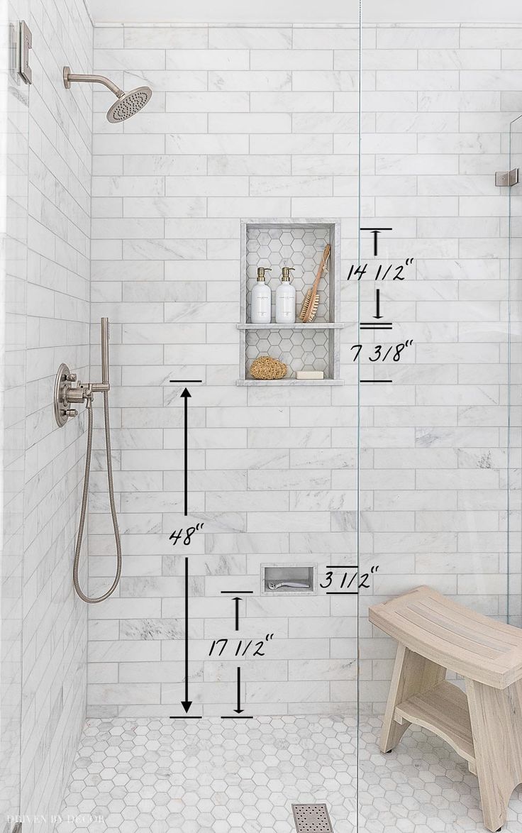 a bathroom with a bench, shower head and shelving on the wall next to it