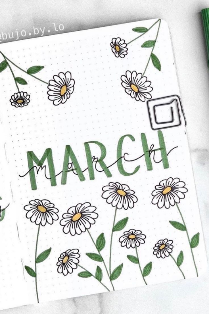 an open notebook with flowers and the word march written in cursive writing on it