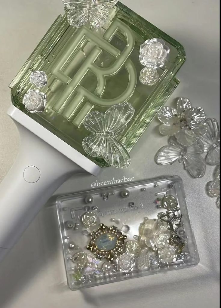 an electric hair dryer sitting on top of a table next to some jewelry and earrings