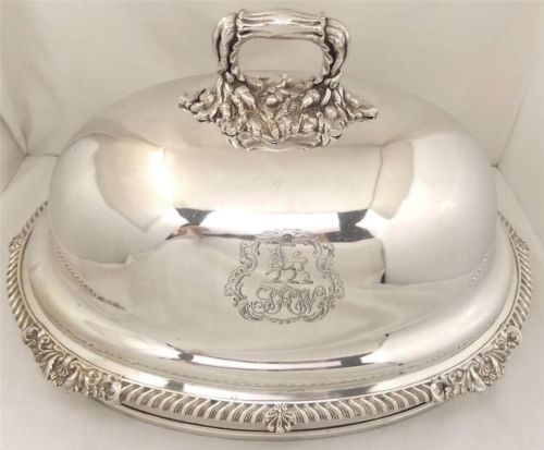 a silver covered dish with ornate designs on it