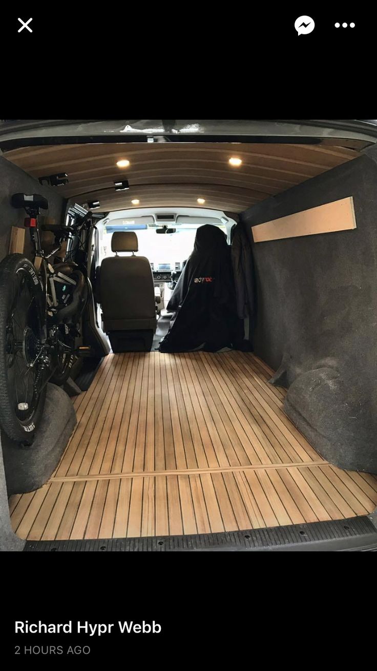 the interior of a van with wood flooring and bikes in the cargo area on either side