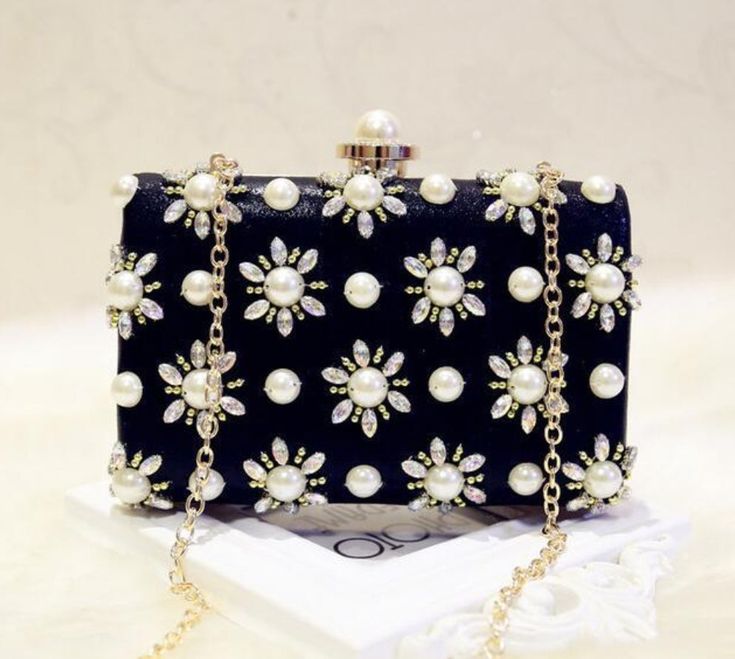 The NAOMI clutch makes a statement with its elegant pearl design. Perfect for a special occasion, this timeless clutch is sure to be a conversation starter. Its stylish design is completed with a magnetic clasp for easy opening and closing. Stylish, chic, and sophisticated, this beautiful clutch is sure to turn heads. Detachable Chain Included Approximate Size: 18 cm (L) x 4-1/2 cm (W) x 13 cm (H) Chic Pearl Clutch For Formal Occasions, Luxury Pearl Clutch For Formal Occasions, Luxury Pearl Evening Bag For Party, Elegant Pearl Evening Bag For Events, Elegant Pearl Bags For Formal Occasions, Evening Pearl Embellished Bag, Luxury Pearl Evening Bag For Events, Luxury Pearl Clutch For Party, Pearl Embellished Evening Bag For Party