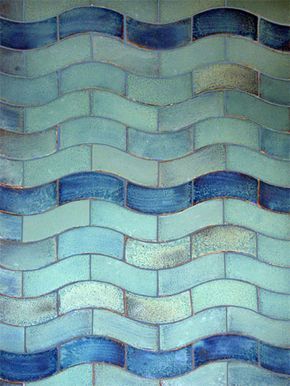 a blue and white tile wall with wavy waves on it's sides, as well as the bottom half