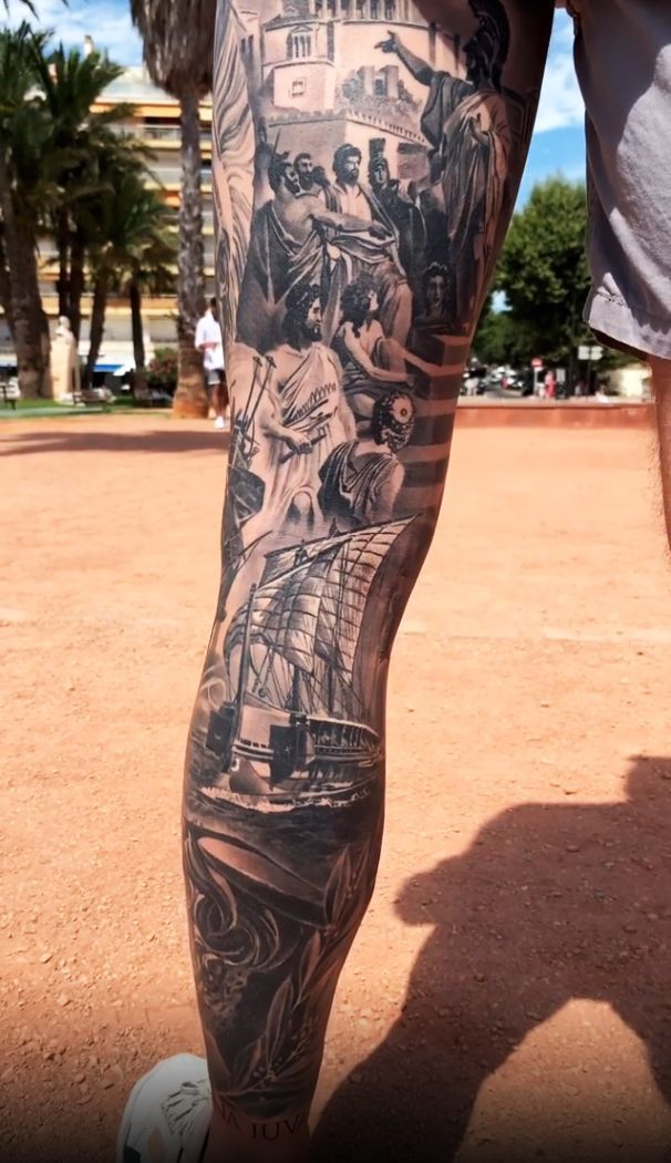 a man's leg with tattoos on it