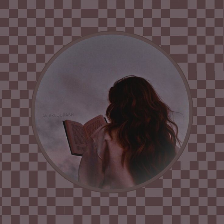 a woman reading a book while standing in front of a checkered background