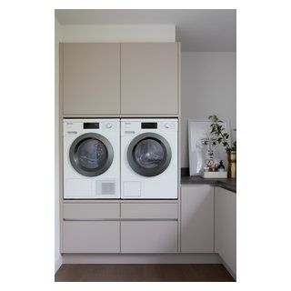 a washer and dryer sitting in a kitchen next to each other on top of cabinets