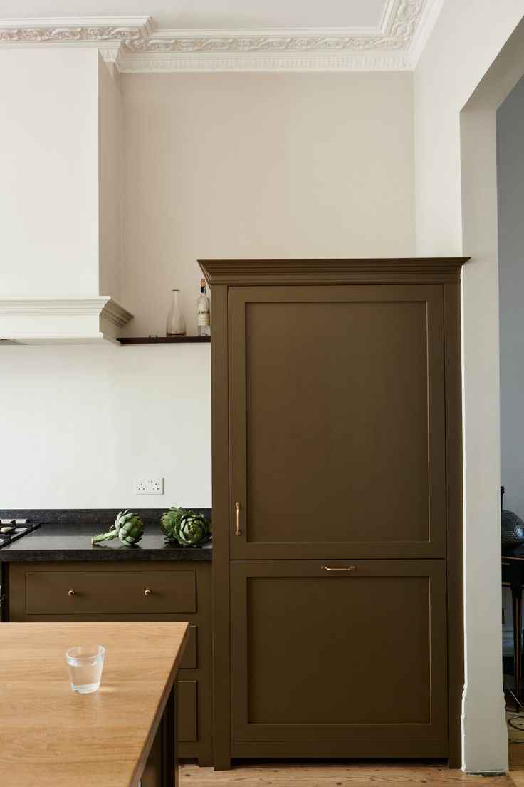 a kitchen with green cabinets and white walls