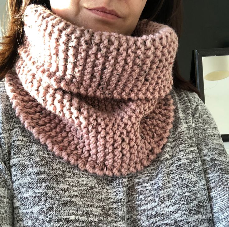 a woman wearing a pink knitted cowl