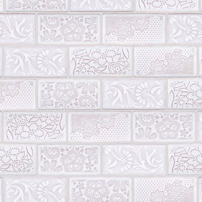 a white brick wall with decorative designs on it