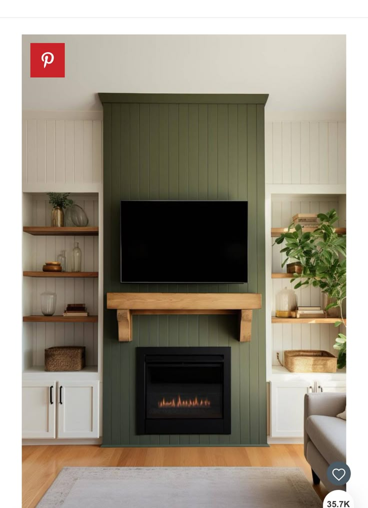 a flat screen tv mounted on the wall above a fireplace in a living room with green walls