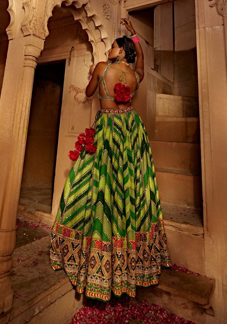 Make a style statement like a traditional diva in this alluring lehenga set featuring a geometrical print skirt with a multi-colour embroidered border and an intricately embroidered blouse styled with a coordinated dupatta. Green Lehenga With Unstitched Blouse For Navratri, Designer Green Lehenga With Unstitched Blouse, Bohemian Green Choli With Cutdana, Bohemian Green Georgette Choli, Green Bohemian Choli With Cutdana, Bohemian Green Sharara For Reception, Festive Green Dress With Unstitched Blouse, Green Georgette Lehenga For Navratri, Green Unstitched Choli With Mirror Work