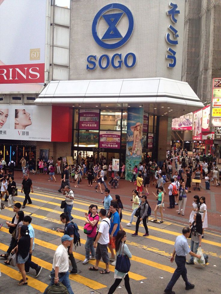 many people crossing the street in front of a store