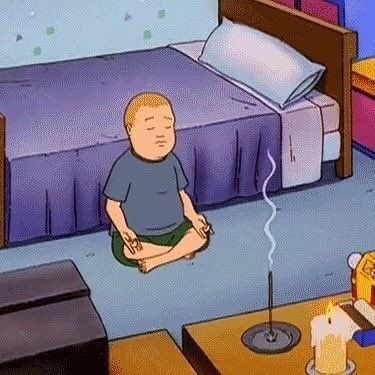 a boy sitting on the floor in front of a bed with an electric outlet plugged into it