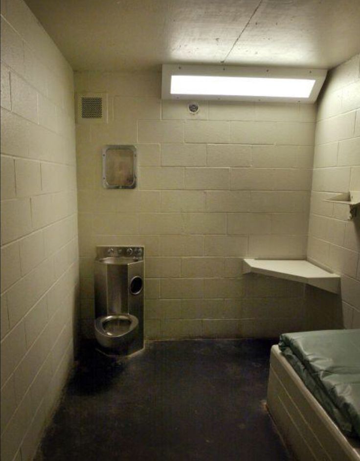 an empty room with a urinal, sink and toilet in it's corner