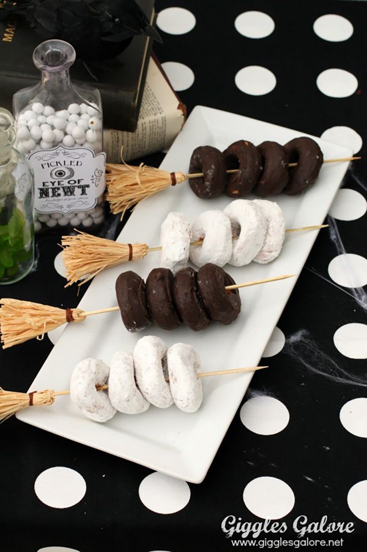 marshmallows and chocolate covered donuts are arranged on a long white plate