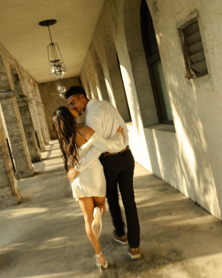 a man and woman are kissing in an alley