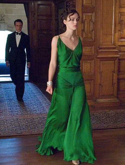 a woman in a long green dress is walking