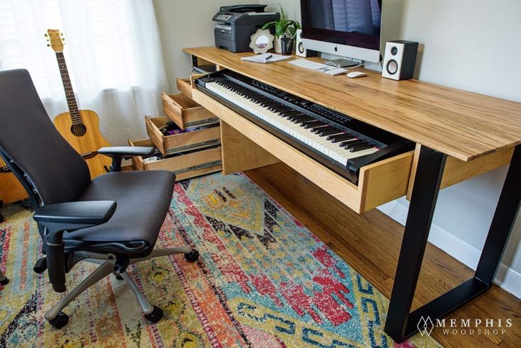 a computer desk with a keyboard and chair in front of it on top of a rug